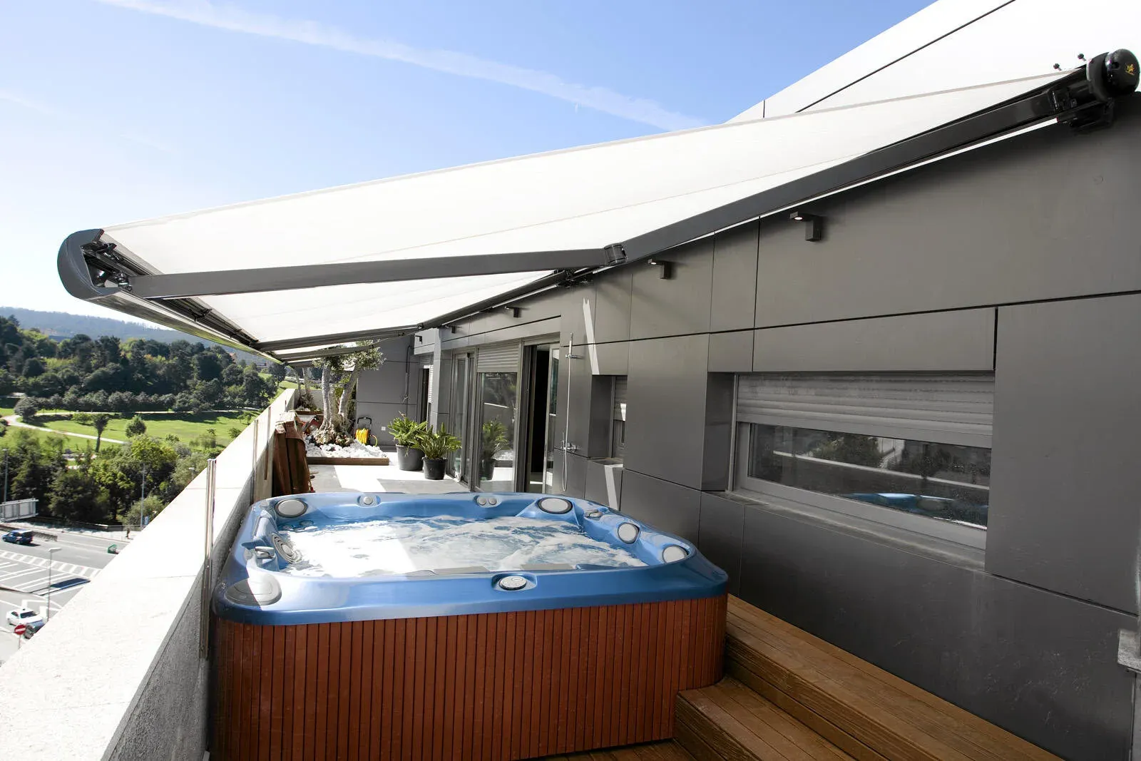 Toldo enrollable cubriendo balcón con vista al mar.